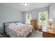 Bedroom features double windows, pale blue walls, and neutral patterned bedding at 4508 Alice Dr, Oxford, NC 27565