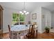 Dining room with wood table and chairs, chandelier, wood floors and large window with backyard view at 4508 Alice Dr, Oxford, NC 27565