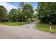 Well-manicured lawn and a lengthy gravel driveway lead to a cozy single-story home surrounded by trees at 4508 Alice Dr, Oxford, NC 27565