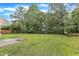Spacious backyard featuring green lawn, large mature trees with partial view of neighbor's home at 5025 Stonewood Pines Dr, Knightdale, NC 27545