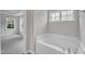 Relax in the soaking tub with bright windows and a view into an adjacent room at 5025 Stonewood Pines Dr, Knightdale, NC 27545
