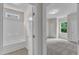 View into the bathroom with a shower and tub combo and a bedroom with carpet and window at 5025 Stonewood Pines Dr, Knightdale, NC 27545