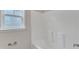 This bright bathroom features a clean, white bathtub and a window with decorative glass at 5025 Stonewood Pines Dr, Knightdale, NC 27545