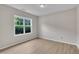 Bright bedroom with neutral walls, light wood floors, and a large window at 5025 Stonewood Pines Dr, Knightdale, NC 27545