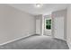 Bedroom with neutral walls, carpet, a window to the backyard, and white doors at 5025 Stonewood Pines Dr, Knightdale, NC 27545