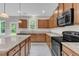 Well-appointed kitchen features wood cabinets, stainless steel appliances, granite countertops, and a breakfast bar at 5025 Stonewood Pines Dr, Knightdale, NC 27545