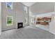Bright living room with fireplace, tall windows, and view to the kitchen at 5025 Stonewood Pines Dr, Knightdale, NC 27545