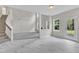 Bright living room with luxury vinyl flooring, stairs, and multiple windows showcasing the outdoor landscape at 5025 Stonewood Pines Dr, Knightdale, NC 27545