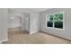 Spacious living room featuring neutral walls, light wood floors, and a large window at 5025 Stonewood Pines Dr, Knightdale, NC 27545