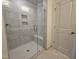 Shower with clear glass door, seating, and tiled walls in new home at 5029 Jowetts Walk Dr # 29, Cary, NC 27519