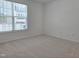 A bright empty bedroom with a large window, neutral carpet, and white walls at 5029 Jowetts Walk Dr # 29, Cary, NC 27519