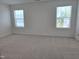 Carpeted bedroom with two large windows offering natural light and neighborhood views at 5029 Jowetts Walk Dr # 29, Cary, NC 27519
