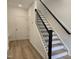 A naturally lit entryway showcasing a staircase with black railings and wood-look flooring at 5029 Jowetts Walk Dr # 29, Cary, NC 27519