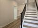 Bright entryway with staircase and wood-look flooring leading to a mudroom bench at 5029 Jowetts Walk Dr # 29, Cary, NC 27519