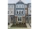 New construction townhome featuring a stone facade, blue accents and crisp white-framed windows at 5029 Jowetts Walk Dr # 29, Cary, NC 27519