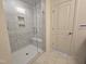 This bathroom features a glass-enclosed shower with tiled walls, a built-in seat and multiple recessed shelves at 5029 Jowetts Walk Dr # 29, Cary, NC 27519