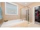 Bright bathroom featuring soaking tub, tiled shower, and linen closet at 522 Finnbar Dr, Cary, NC 27519