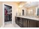 Double vanity bathroom featuring granite countertops, dark cabinets, and a walk-in closet at 522 Finnbar Dr, Cary, NC 27519
