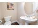 Half bath with a modern pedestal sink, stylish faucet, and decorative artwork at 522 Finnbar Dr, Cary, NC 27519
