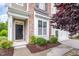 Close-up of the front entrance, highlighting the black door, brick accents, and meticulously maintained landscaping at 522 Finnbar Dr, Cary, NC 27519