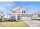Beautiful two-story home with a brick and white siding, a two-car garage, and a well-manicured lawn at 604 Salmonberry Dr, Holly Springs, NC 27540