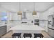Modern kitchen with white cabinets, quartz countertops, stainless steel appliances, and a large center island at 604 Salmonberry Dr, Holly Springs, NC 27540