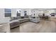 Spacious living room with large sectional sofa, hardwood floors, and natural light, ideal for entertaining at 604 Salmonberry Dr, Holly Springs, NC 27540