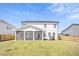 Back of the home featuring a screened in porch and a well-maintained lawn; ideal for outdoor activities and gatherings at 604 Salmonberry Dr, Holly Springs, NC 27540