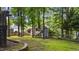 View of a spacious green backyard including a playground and a storage shed surrounded by trees at 6717 Ebon Ct, Raleigh, NC 27615