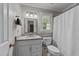 Bright bathroom with a vanity, window, and shower with white shower curtain at 6717 Ebon Ct, Raleigh, NC 27615