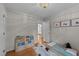 Neutral bedroom features a wooden bookstand, wall art and warm hardwood floors at 6717 Ebon Ct, Raleigh, NC 27615