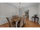 Bright dining room with hardwood floors, chandelier, and view into the living room at 6717 Ebon Ct, Raleigh, NC 27615