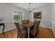 Dining room with hardwood floors, chandelier lighting, and window views of the backyard at 6717 Ebon Ct, Raleigh, NC 27615