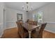 Elegant dining room featuring hardwood floors, chandelier lighting, and views of the backyard at 6717 Ebon Ct, Raleigh, NC 27615