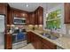 Spacious kitchen featuring stainless steel appliances, granite countertops, and warm wooden cabinetry at 6717 Ebon Ct, Raleigh, NC 27615