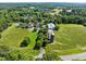 Aerial view of a property featuring a silo, farm land, pastures, lush trees, and a white fence at 676 Whitehurst, Pittsboro, NC 27312