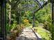 Backyard arbor with decorative pavers and bench seating, surrounded by mature trees at 676 Whitehurst, Pittsboro, NC 27312