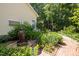 Landscaped backyard featuring a fountain, brick path, and lush greenery, creating a peaceful outdoor space at 676 Whitehurst, Pittsboro, NC 27312