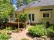 Charming backyard featuring a brick path, lush garden, and a wooden deck, perfect for outdoor relaxation at 676 Whitehurst, Pittsboro, NC 27312