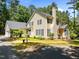 Traditional two-story home featuring a manicured lawn, brick walkway, mature trees, and a classic design at 676 Whitehurst, Pittsboro, NC 27312