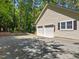 Exterior view of the home with a three-car garage and landscaping, showcasing its curb appeal at 676 Whitehurst, Pittsboro, NC 27312