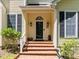 Inviting front entrance with brick steps, black door, and charming details enhancing the home's curb appeal at 676 Whitehurst, Pittsboro, NC 27312