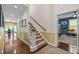 Hallway featuring hardwood floors, staircase, and an inviting view into a living room with comfortable seating at 676 Whitehurst, Pittsboro, NC 27312