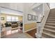 Hallway with staircase providing access to a living room with plush seating and abundant natural light at 676 Whitehurst, Pittsboro, NC 27312