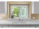 Close-up on a kitchen sink in front of a window with a view of the backyard at 676 Whitehurst, Pittsboro, NC 27312