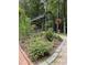 Beautiful backyard garden with a decorative metal pergola and various plants at 676 Whitehurst, Pittsboro, NC 27312
