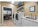 Bright laundry room with modern washer and dryer, sink, and storage shelves at 676 Whitehurst, Pittsboro, NC 27312