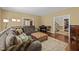 Living room featuring a brown sectional sofa, tufted ottoman, a piano and dark hardwood floors at 676 Whitehurst, Pittsboro, NC 27312