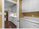 A kitchen with hardwood floors, walk-in pantry, and white cabinets and countertops at 676 Whitehurst, Pittsboro, NC 27312