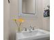 Stylish powder room features a pedestal sink, modern fixtures, fresh flowers and a framed mirror at 676 Whitehurst, Pittsboro, NC 27312